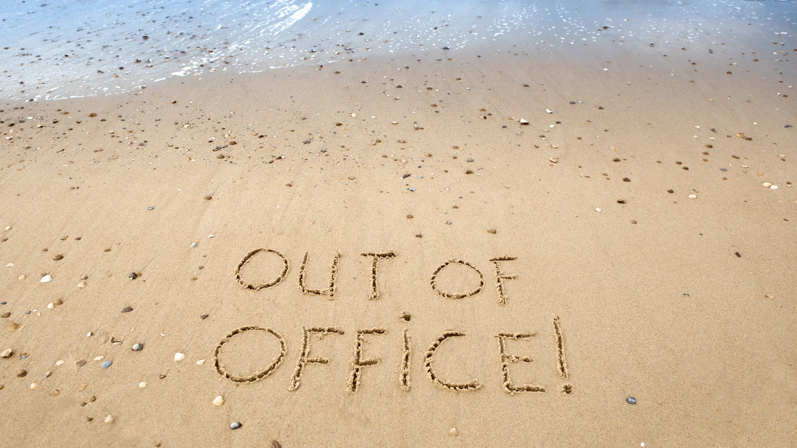 Kumsala yazılmış "Out of Office" yazısıyla ofis dışı motivasyon artırıcı organizasyon konsepti